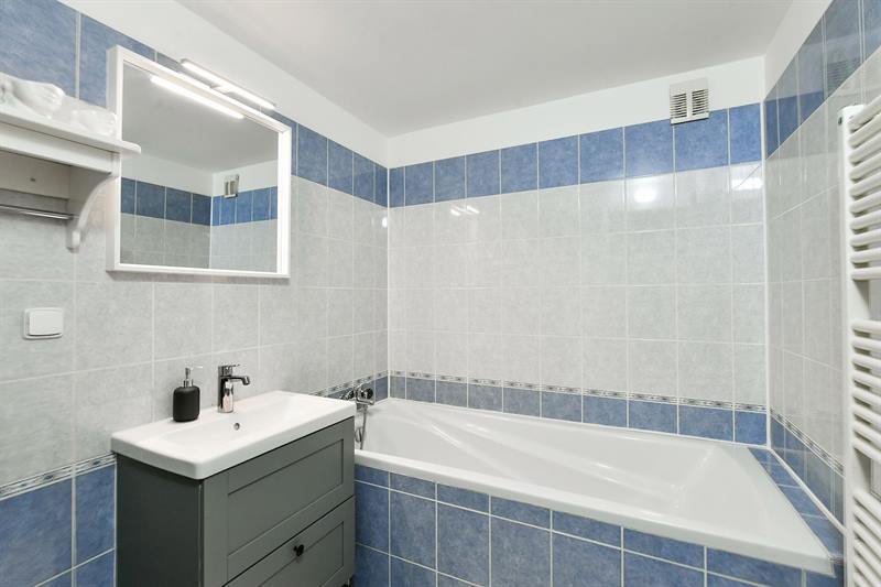 Bathroom with bathtub, blue and white tiles and heated towel rail