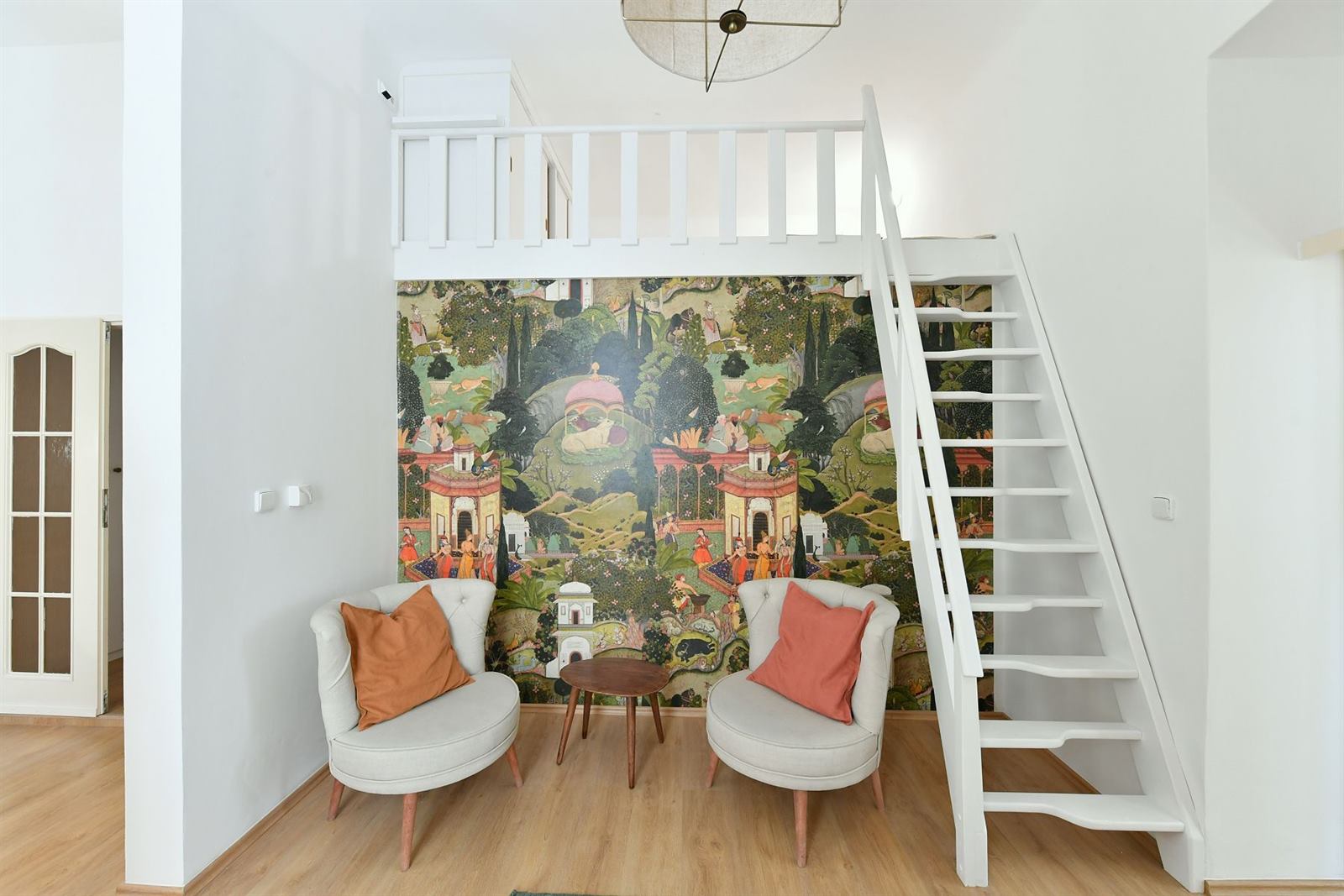Sleeping mezzanine above a hand-painted garden mural wall with two armchairs